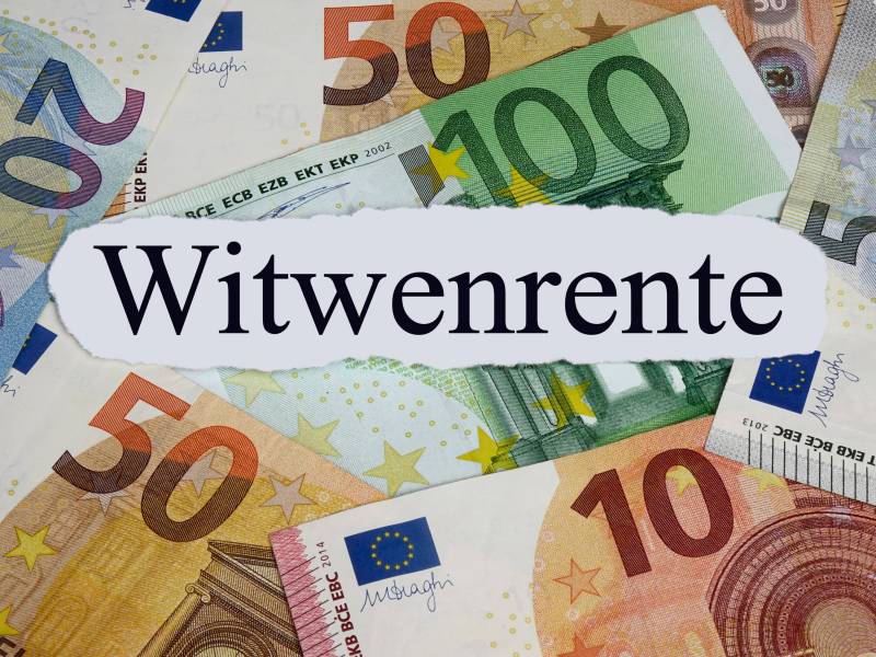 Zwischen Geldscheinen liegt ein weißer Zettel mit der Aufschrift 