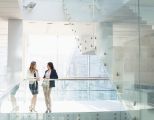 Zwei Frauen unterhalten sich im Büroflur.