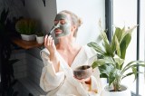 Frau trägt Gesichtsmaske auf