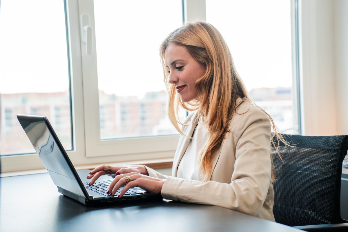 Geschäftsfrau arbeitet mit Laptop am Schreibtisch.