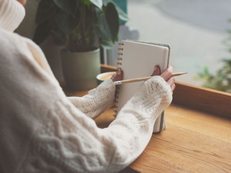 Frau hÃ¤lt Ta-Da-Liste Notizblock in der Hand