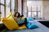 Frau arbeitet in der Chill-out-Zone im BÃ¼ro an ihrem Laptop.