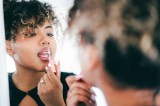 Frau trägt Lipgloss auf