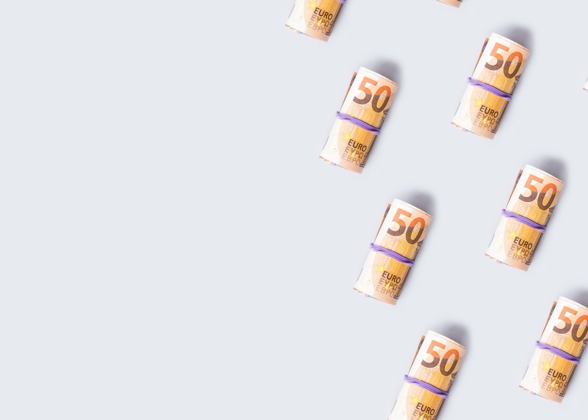 50-Euro-Banknotenrollen auf grauem Hintergrund.