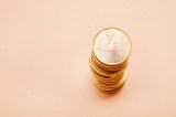 Stapel von Ein-Euro-Münzen auf beigen Hintergrund.