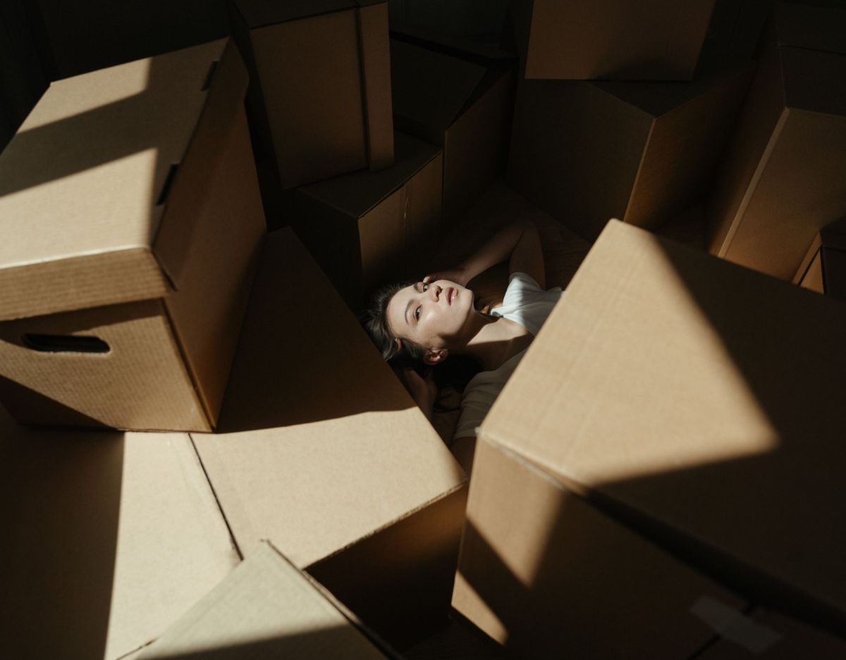 Frau liegt inmitten von Boxen