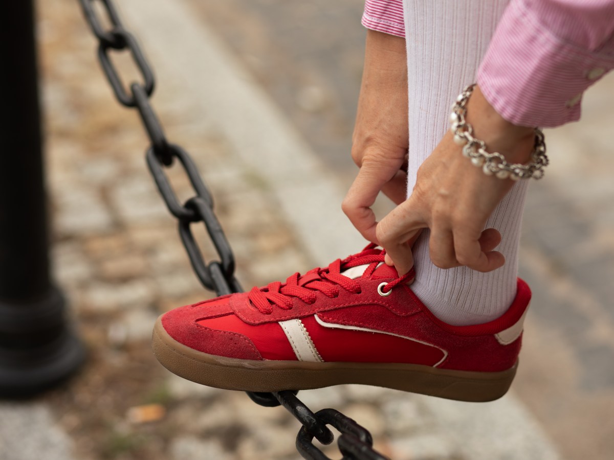 Frau zieht Schuh an