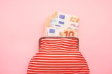 Aufnahme einer Brieftasche und Euro-Banknoten auf rosa Hintergrund.