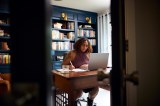 Eine Frau arbeitet in ihrem Home-Office an einem Laptop.