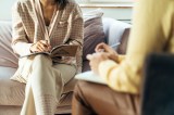 Zwei Frauen in Sesseln sitzen und unterhalten sich.