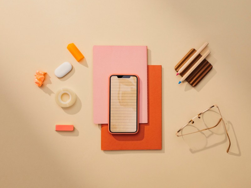 Büromaterialien: ein minimalistisches Stillleben auf einem Tisch mit einem Smartphone.