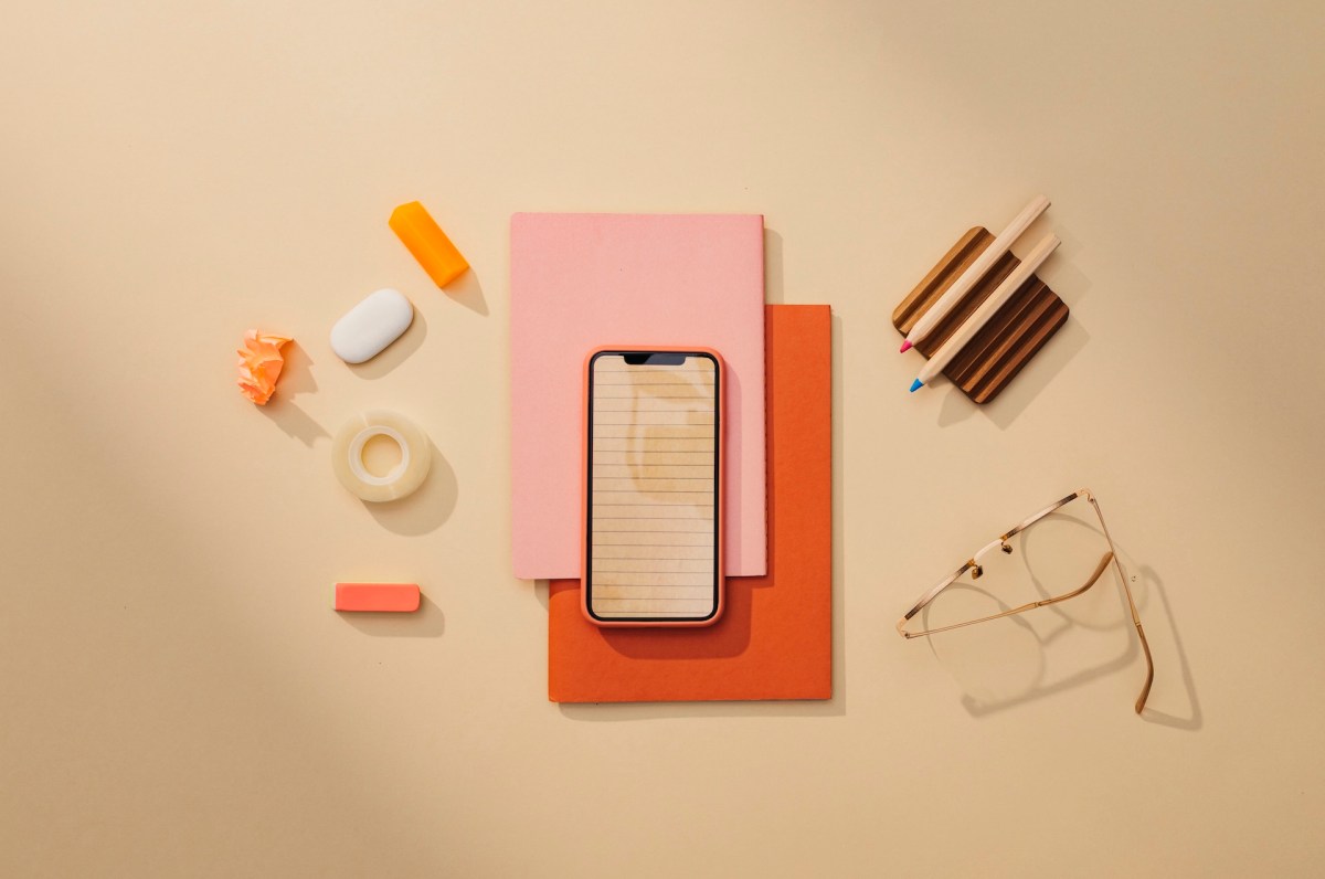 Büromaterialien: ein minimalistisches Stillleben auf einem Tisch mit einem Smartphone.