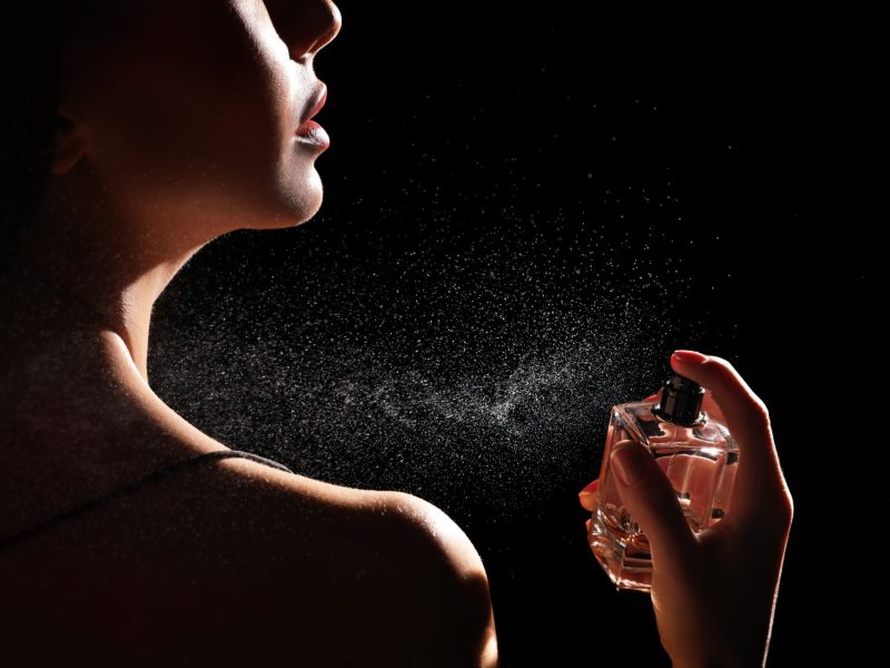 Frau trägt Parfum auf