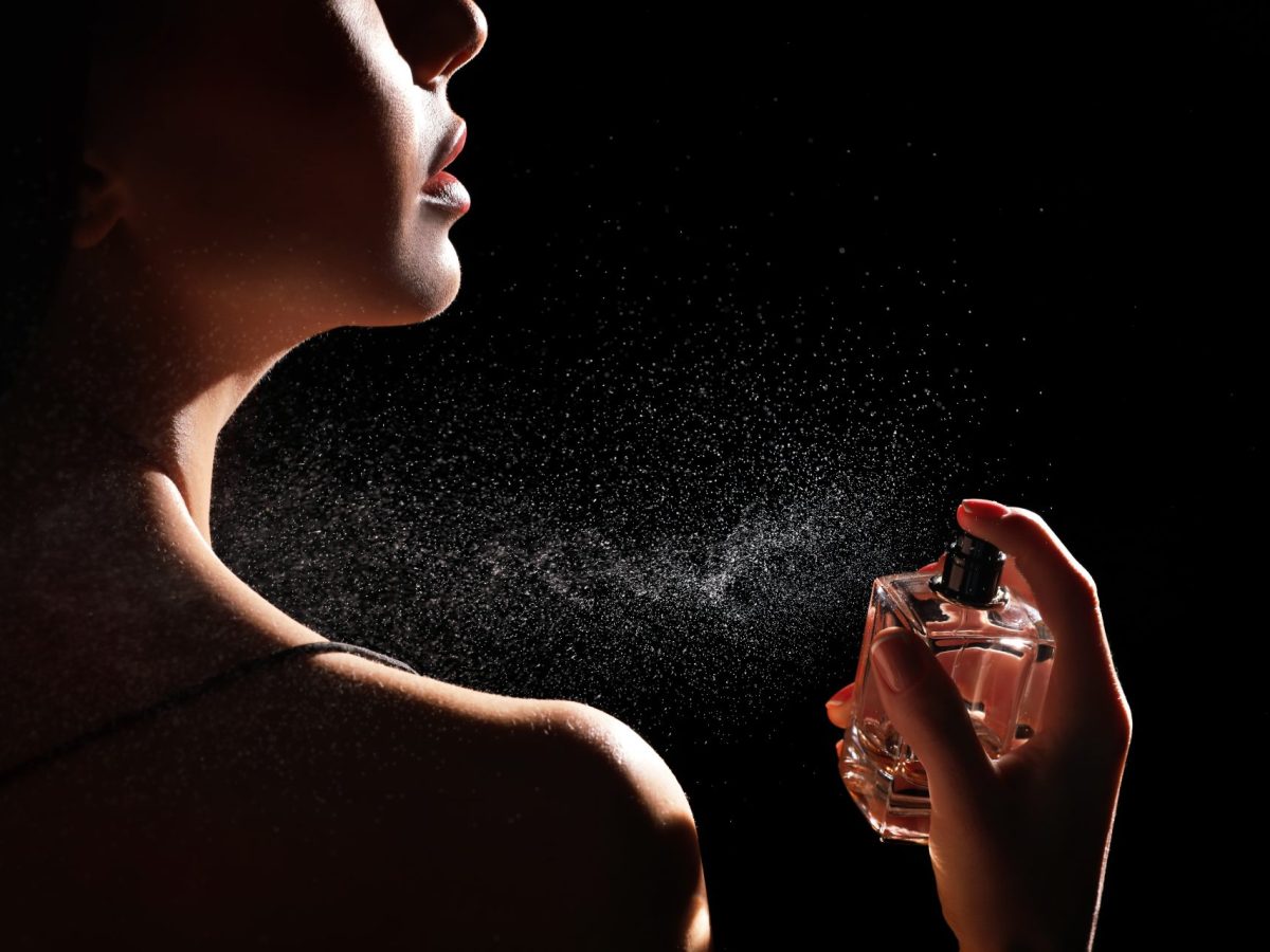 Frau trägt Parfum auf