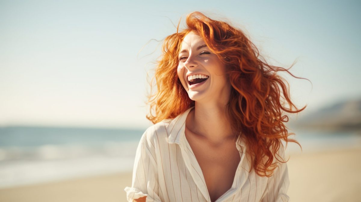 Frau am Strand mit roten Haaren