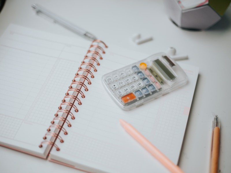 Taschenrechner, Stift, Papier, auf dem Desktop
