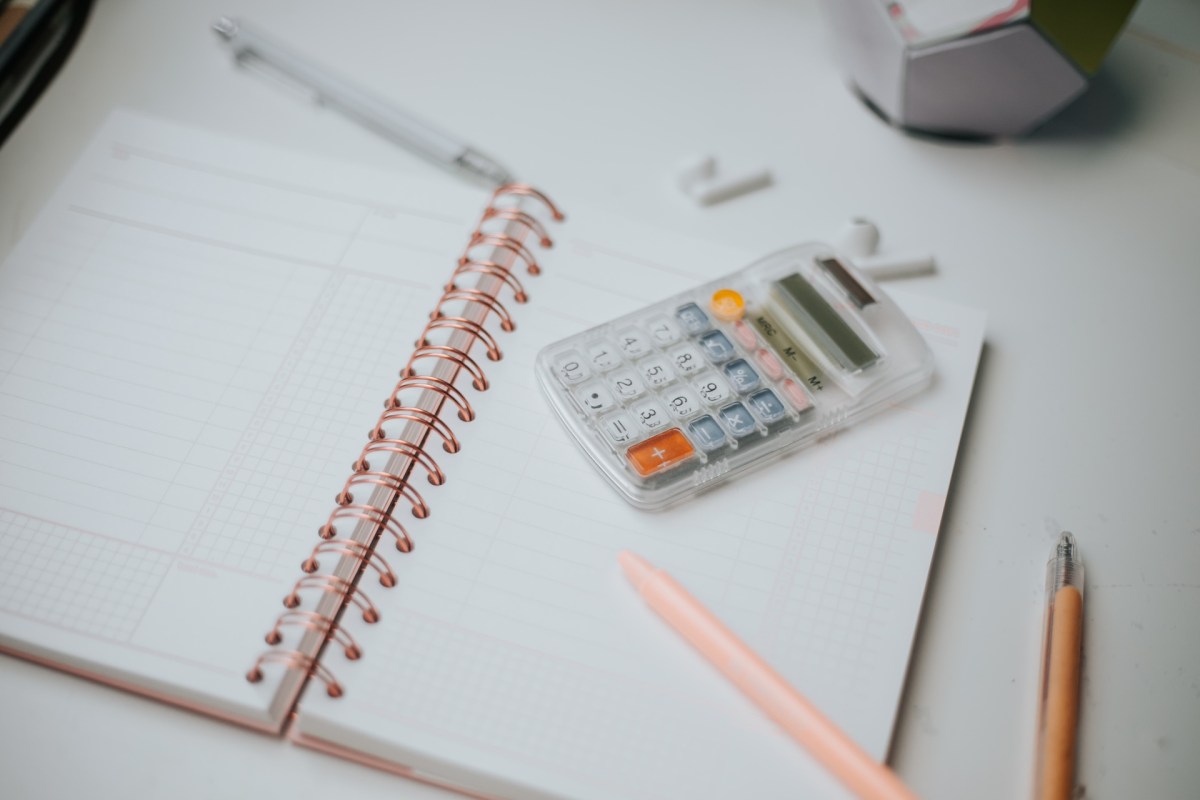 Taschenrechner, Stift, Papier, auf dem Desktop