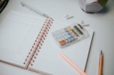 Taschenrechner, Stift, Papier, auf dem Desktop