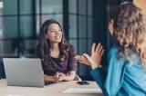 Zwei Frauen führen in einem Meetingraum ein Gespräch.