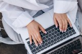 Eine Frau tippt auf dem Laptop.