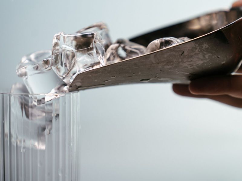 Hand macht Eis in ein Glas