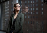 Eine Frau schaut nachdenklich aus dem Fenster.
