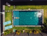 Eine Frau liegt im Pool. Ansicht von oben.