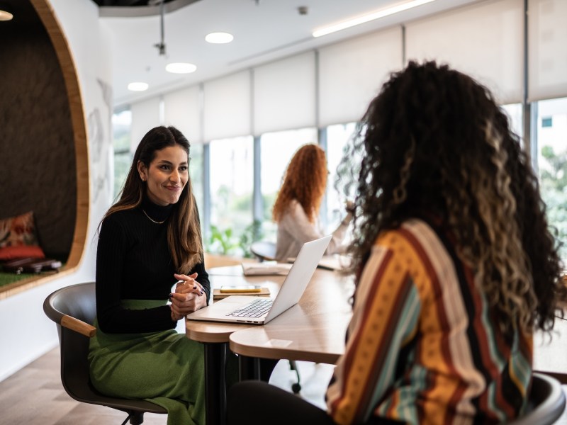 Zwei Frauen führen im Büro ein Gespräch.