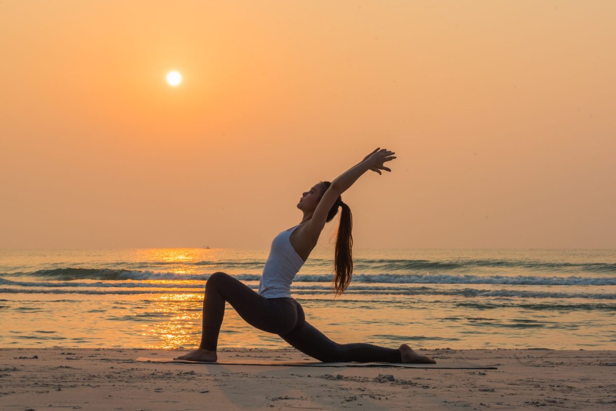Frau macht Yoga am Strand