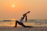 Frau macht Yoga am Strand