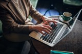 Eine Frau arbeitet im Café am Laptop.