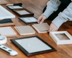 Frau rahmt Bilder in Bilderrahmen ein