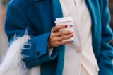 Frau mit Nägeln hält Kaffee