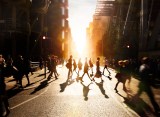 Geschäftsleute überqueren bei Sonnenuntergang die Straße.