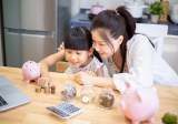 Mädchen und ihre Mutter lernen Mathematik mit Bargeld und Geldplanung.