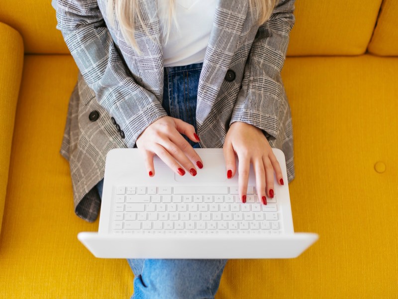 Eine Frau tippt auf dem Laptop.