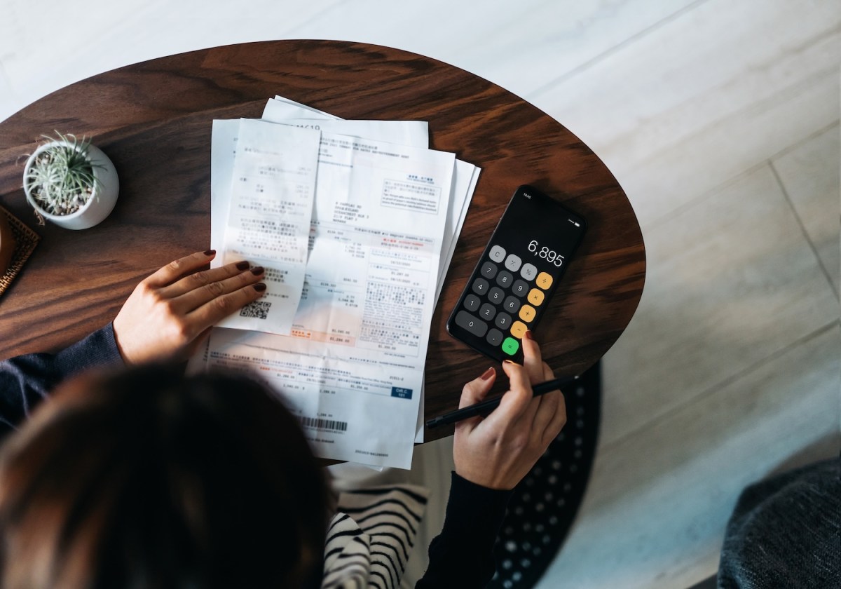Draufsicht einer jungen Asiatin, die zu Hause ihre Finanzen verwaltet.