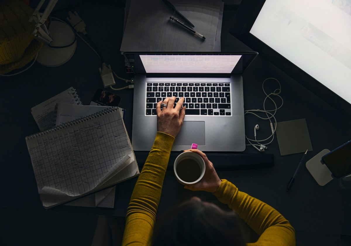 Eine Frau sitzt abends an ihrem Laptop und arbeitet.