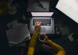 Eine Frau sitzt abends an ihrem Laptop und arbeitet.