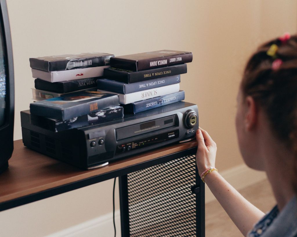 Frau bedient einen VHS-Player mit VHS-Kasetten