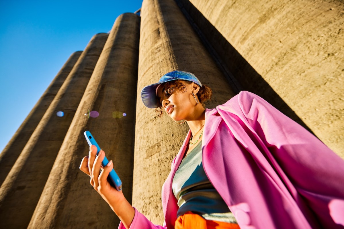 Junge Frau schaut auf ihr Handy.