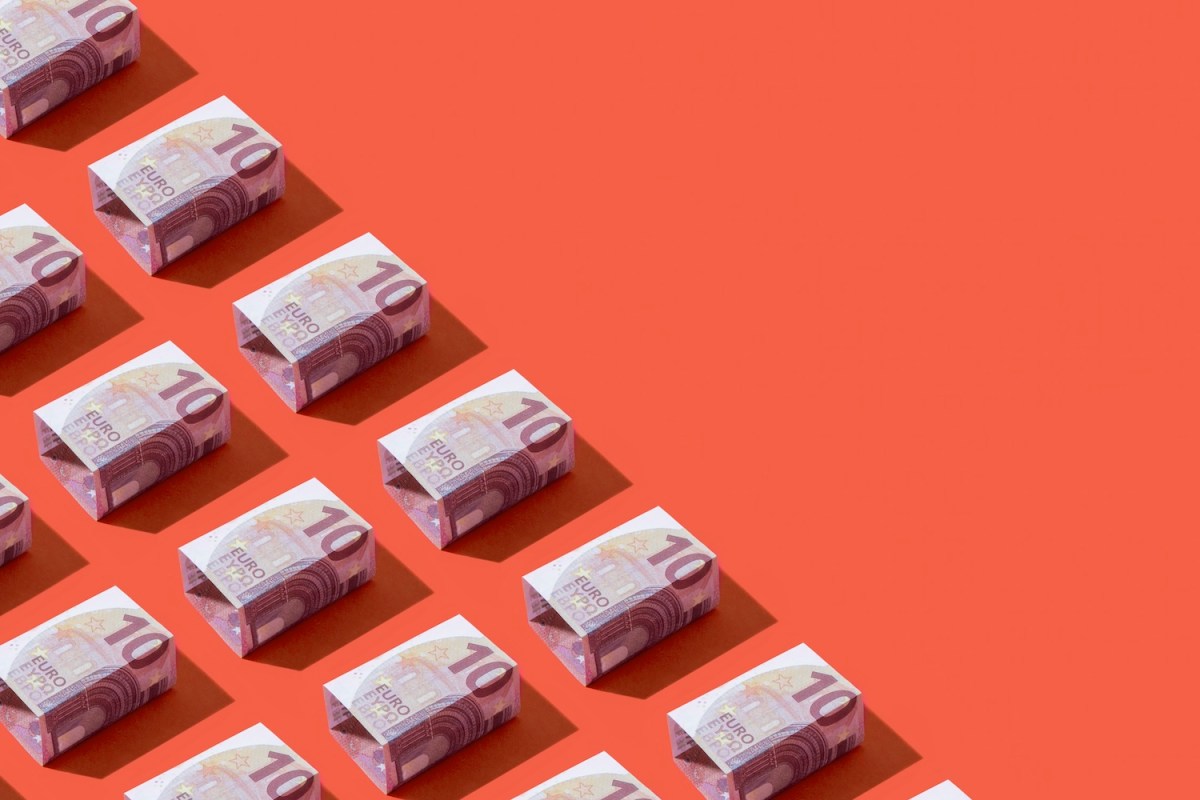 Quadratische zehn Euro-Banknoten in einer Reihe auf rotem Hintergrund.