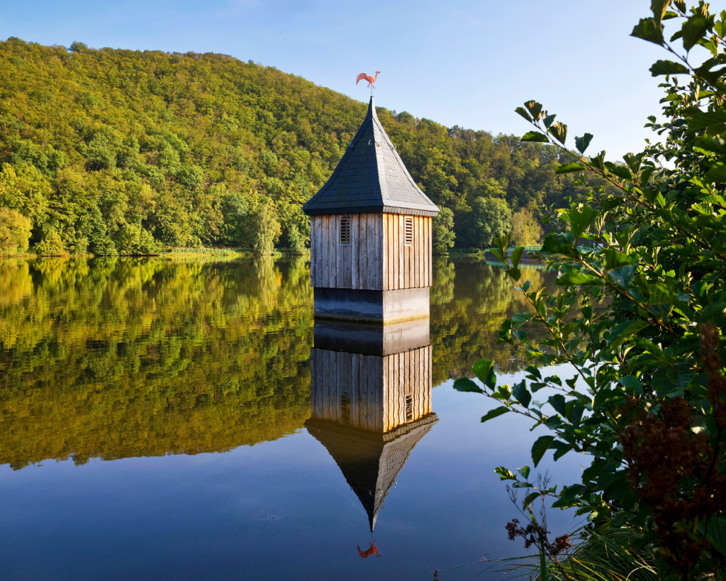 Die bekannte Kirchturmspitze im Reiherbach-Vorstaubecken am Edersee, die an die alte Dorfkirche des Ortes erinnert.