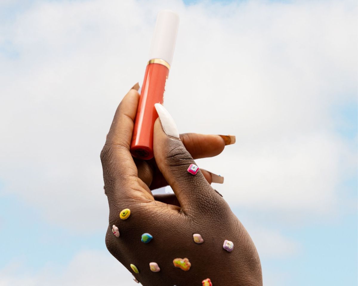 Frau hält einen Lipgloss in die Luft Balea-Dupe