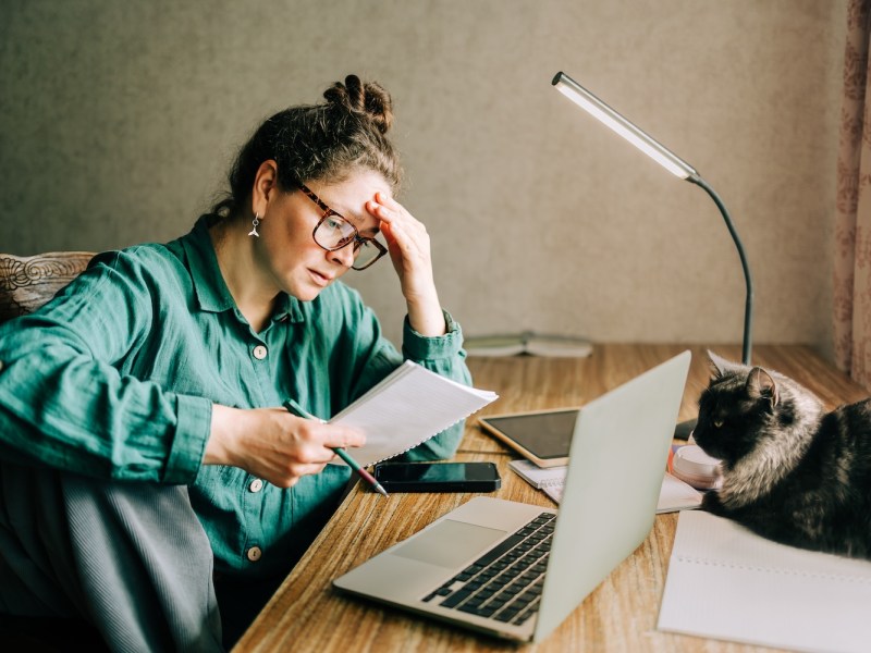 Frau schaut besorgt auf ihre Lernunterlagen.