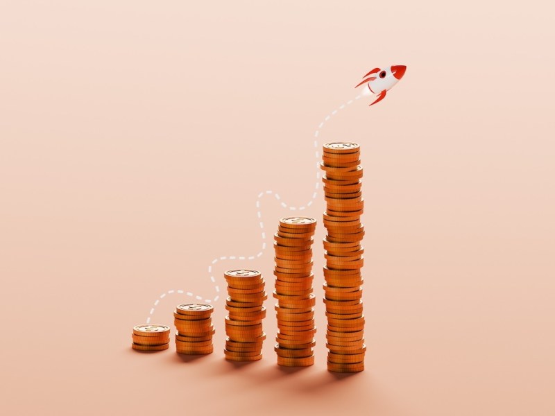 Eine konzeptionelle Illustration zeigt mehrere Stapel Silberdollar-Münzen, die in einem ansteigenden Wachstumsdiagramm angeordnet sind.